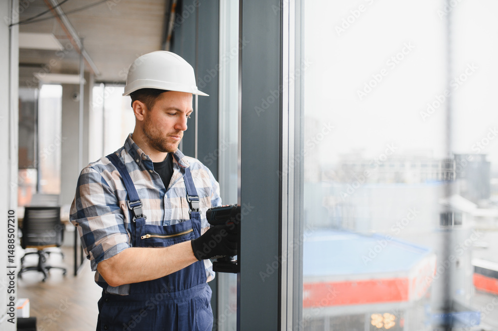Construction worker installing window in modern office building Construction worker installing window in modern office building