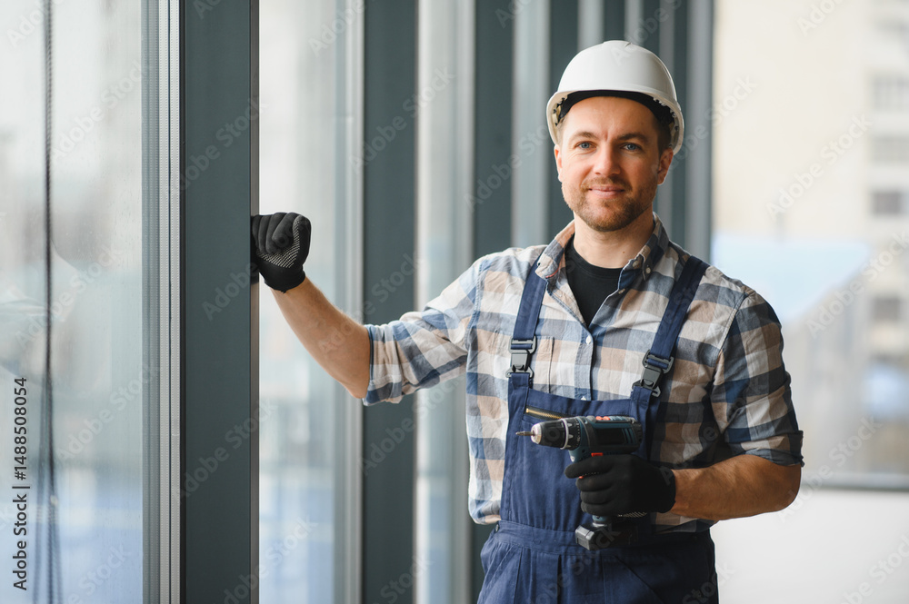 Construction worker installing windows in modern building Construction worker installing windows in modern building