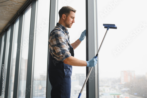 Foto Professional cleaning service worker washing windows in office building