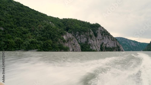 water splashes behind the boat on the Danube among mountains and forests, 4k
