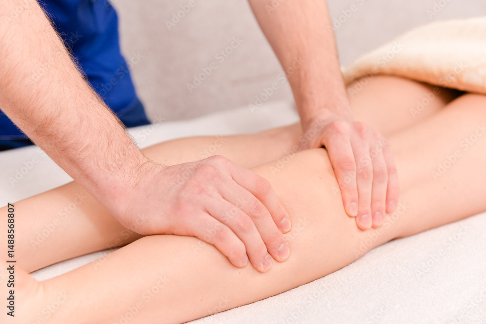 Detail of hands massaging human calf muscle. Detail of hands massaging human calf muscle.