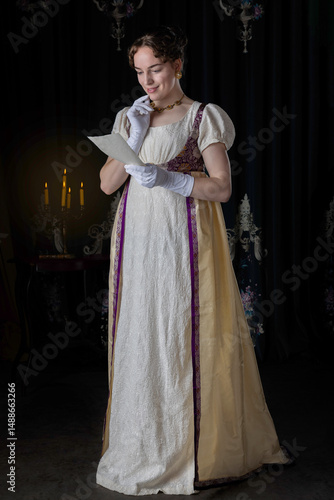 A Regency woman wearing evening attire and holding a letter