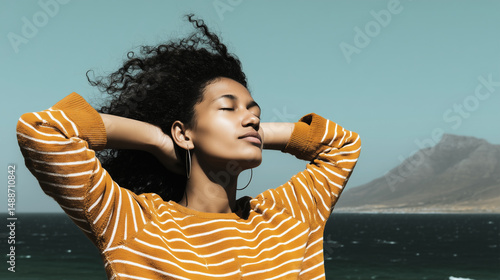 Obraz na płótnie Relaxed young woman enjoying the sea breeze with mountains in the background w salonie