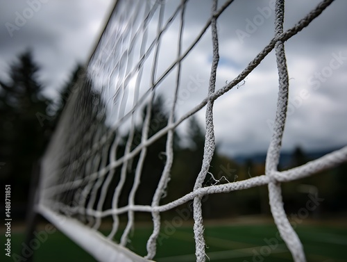 Stretched volleyball net with reinforced white mesh stands ready under arena lights for championship action
