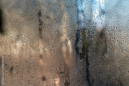 Humid indoor air it forms water droplets and condensation on wet glass. abstract with glass background. foggy window inside apartment, increased humidity and cold form condensation on wet window.