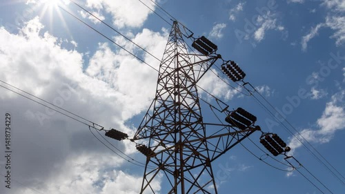 Transmission tower supporting an overhead high voltage power line - dramatic time lapse. The pylon carries wires that transport electric power from generating stations to electrical substations.