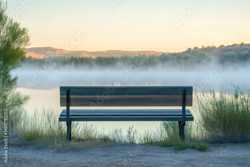 Fototapeta Naklejka Na Ścianę i Meble -  A tranquil scene of a solitary bench overlooking a misty lake at sunrise, offering a peaceful retreat.