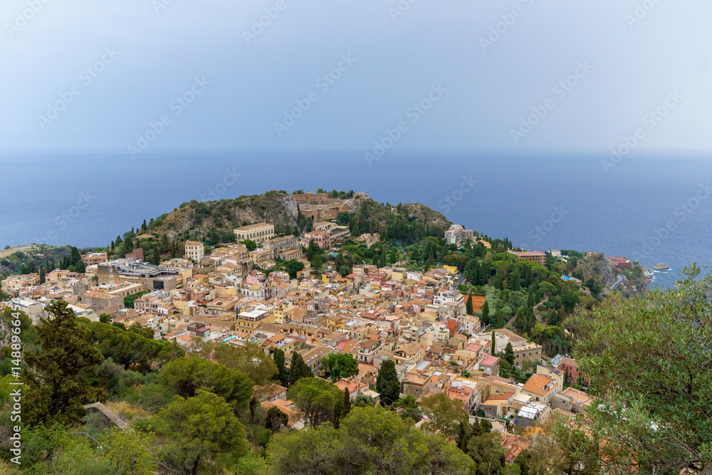 Fototapeta premium View from above Taormina with the medieval city center, the ancient greek theater and the coastline visible on Sicily, Italy 