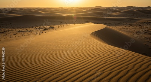 A tranquil desert landscape at sunset with a large sand dune dominating the foreground.