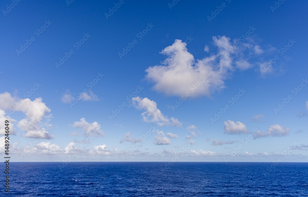 Fototapeta premium Tranquil Ocean and Sky Horizon with Scattered Clouds in Peaceful Daytime Atmosphere