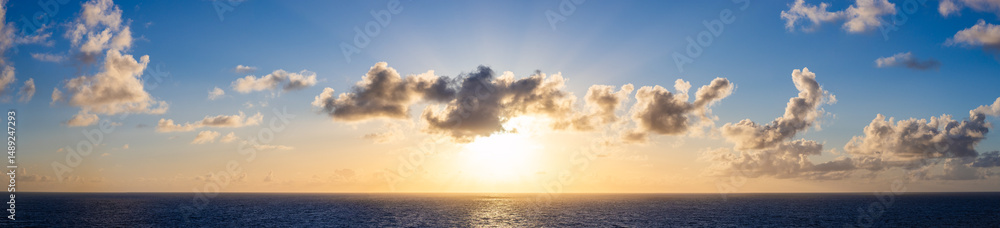 Obraz premium Scenic Sunset Over Ocean with Clouds and Bright Horizon