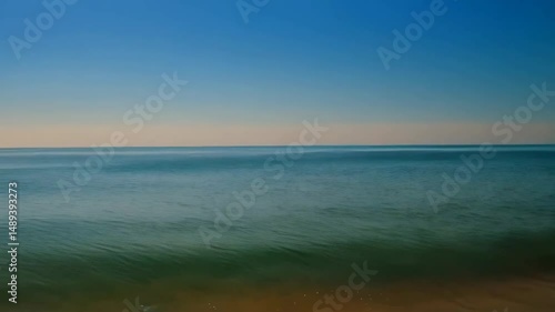 Wallpaper Mural Close-up view of calm sea water and sandy beach shoreline, featuring ocean surface waves on a bright sunny day, creating a peaceful seascape Torontodigital.ca