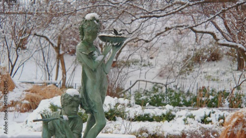 Footage showcases Burnett Fountain under winter snow in Central Park, with bronze figures of Mary and Dickon from The Secret Garden.