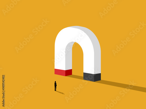 Businessman standing looking at large magnet