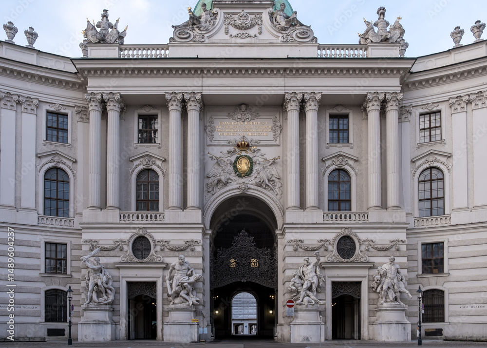 Obraz premium Vienna, Austria – Detail of St. Michael's Wing at Michaelerplatz, the grand Baroque facade of Hofburg Palace's entrance with its monumental dome and sculpted imperial eagles overlooking the square.