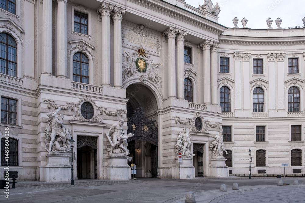 Obraz premium Vienna, Austria – Detail of St. Michael's Wing at Michaelerplatz, the grand Baroque facade of Hofburg Palace's entrance with its monumental dome and sculpted imperial eagles overlooking the square.