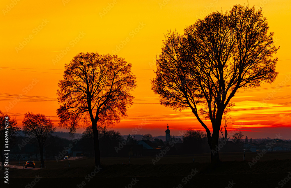 Fototapeta premium Sunset or sundowner with a church silhouette near Wisselsing, Osterhofen, Deggendorf, Bavaria, Germany