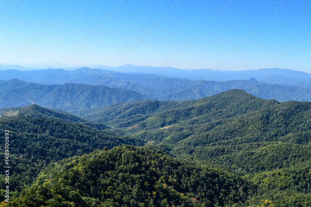 Obraz premium Distant Mountains and Forest with Trees and Sky in Northern Thailand.