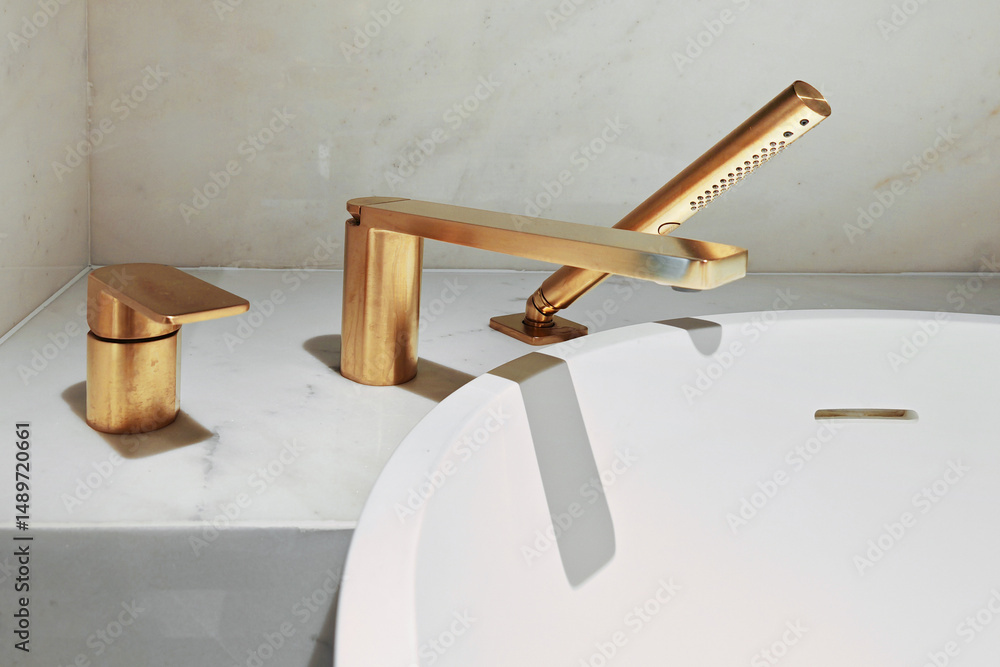 Obraz premium A stylish brass faucet set complements a minimalist bathtub in a luxurious bathroom setting