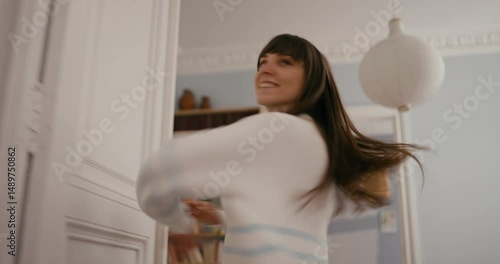 Girl smiling and dancing pirouette and spinning during her classical dance in a cozy apartment at home. Classical Dance and Self-Expression at Home