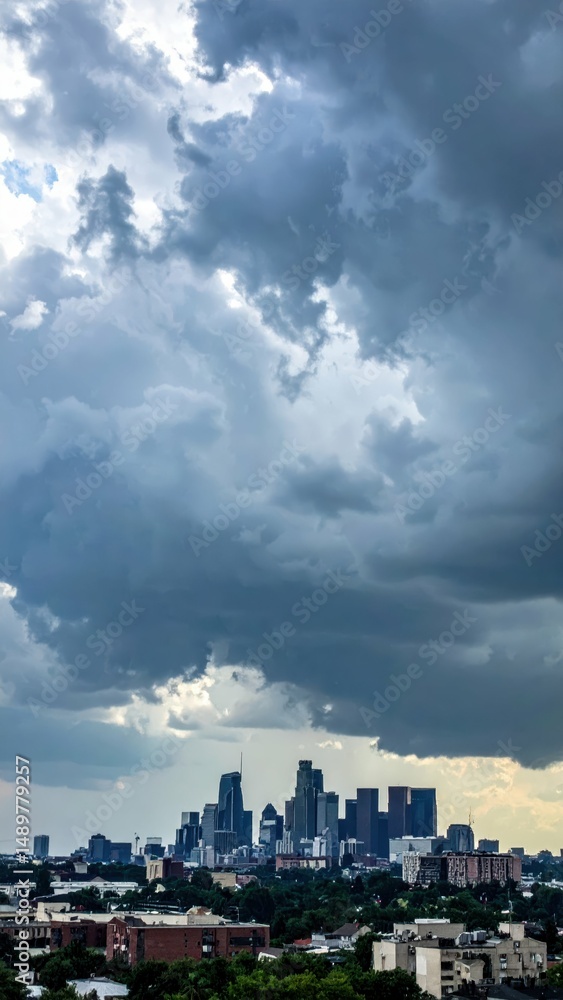 Fototapeta premium Dramatic City Skyline Under Turbulent Sky with Dark Clouds