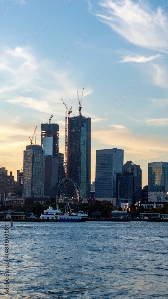 Fototapeta premium City Skyline with Temporary Structures and Cranes at Dusk