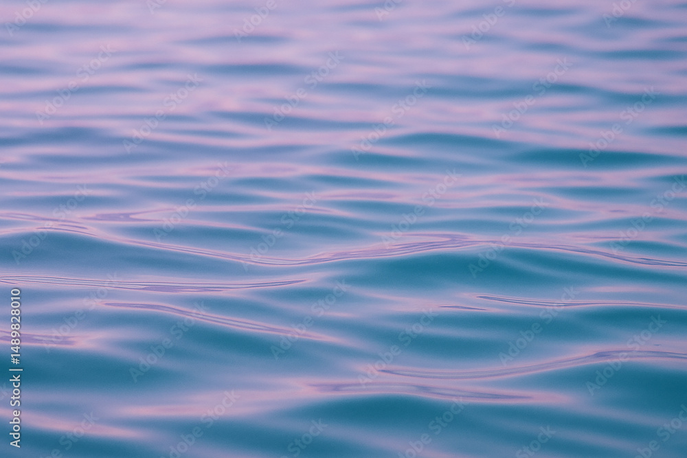 Photorealistic calm water surface with soft waves in lavender and turquoise tones Photorealistic calm water surface with soft waves in lavender and turquoise tones