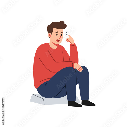 Thoughtful young man sitting on a surface with a pensive expression and copy space
