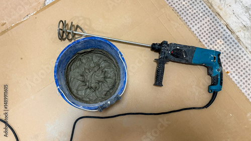 An electric mixer poised beside a bucket of swirling cement, capturing the essence of DIY fervor and Labor Day industriousness