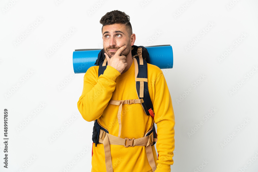 Young mountaineer man with a big backpack over isolated background having doubts Young mountaineer man with a big backpack over isolated background having doubts