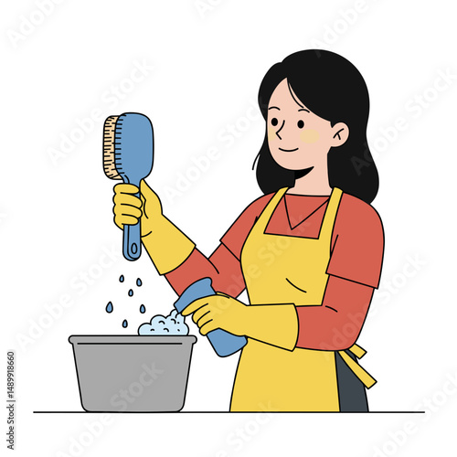 Woman cleaning dishes with scrub brush and soap while wearing gloves in the kitchen