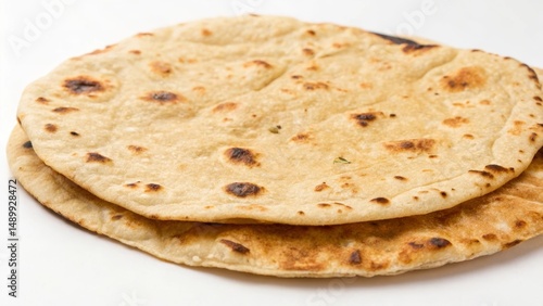 Freshly made flatbreads stacked on a white surface, showcasing texture and color.