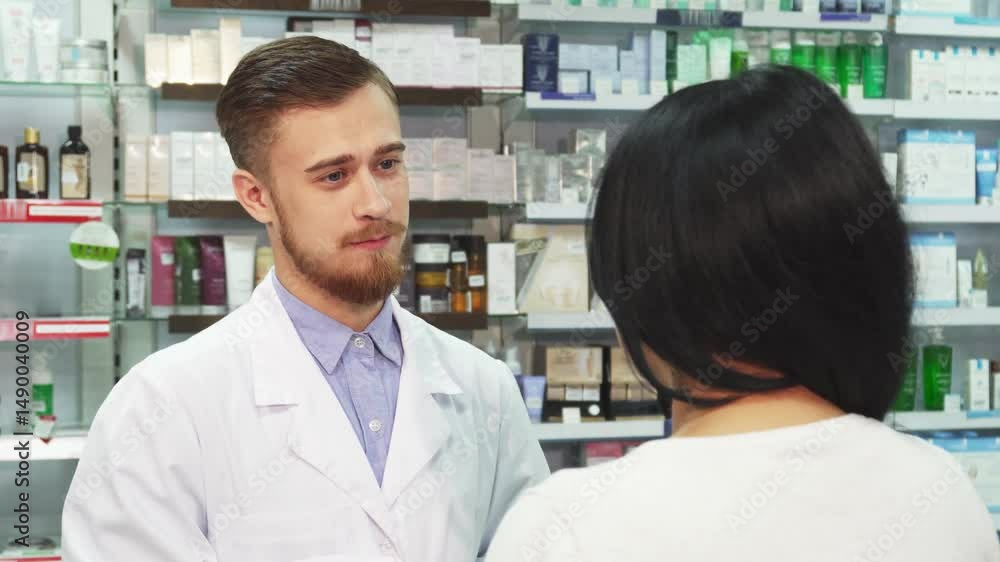 Friendly pharmacist assists a woman with her purchase Friendly pharmacist assists a woman with her purchase
