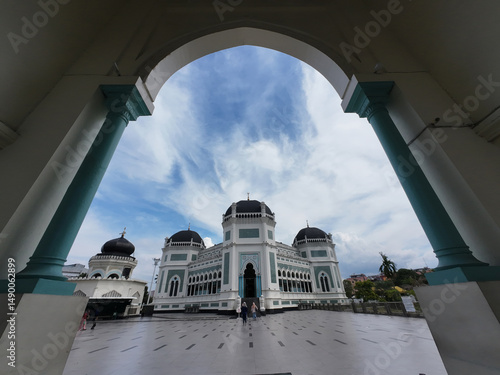 Photos Al-Mashun Grand Mosque in Medan, Indonesia, framed by arch columns, showcasing i