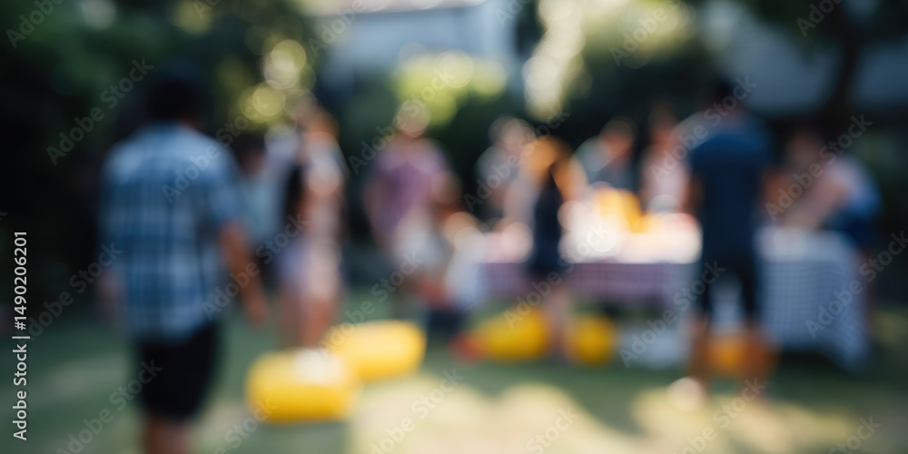 Obraz premium Blurred image of people enjoying garden party with lawn games