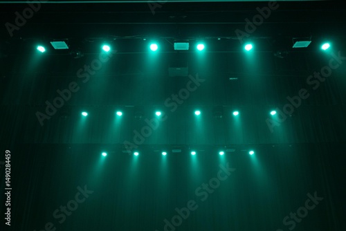 Wallpaper Mural A dimly lit stage bathed in green lighting, with sheets of paper scattered across the floor. Dramatic atmosphere with curtains and stage lights overhead. Copy space included. Torontodigital.ca