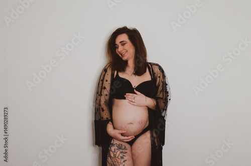 Femme enceinte en sous vêtement noir sur fond blanc