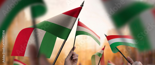 Tableau sur toile Hungary flags in their hands on a blurred urban background