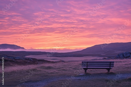 pink and orange sunset over barren landscape with bench