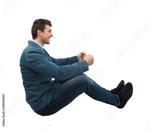 Side view full length portrait of a young smiling businessman driving an imaginary car isolated on transparent background