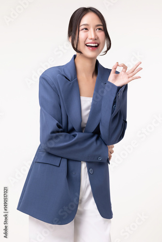 Portrait of happy young business woman posing with OK hand sign isolated on white background.