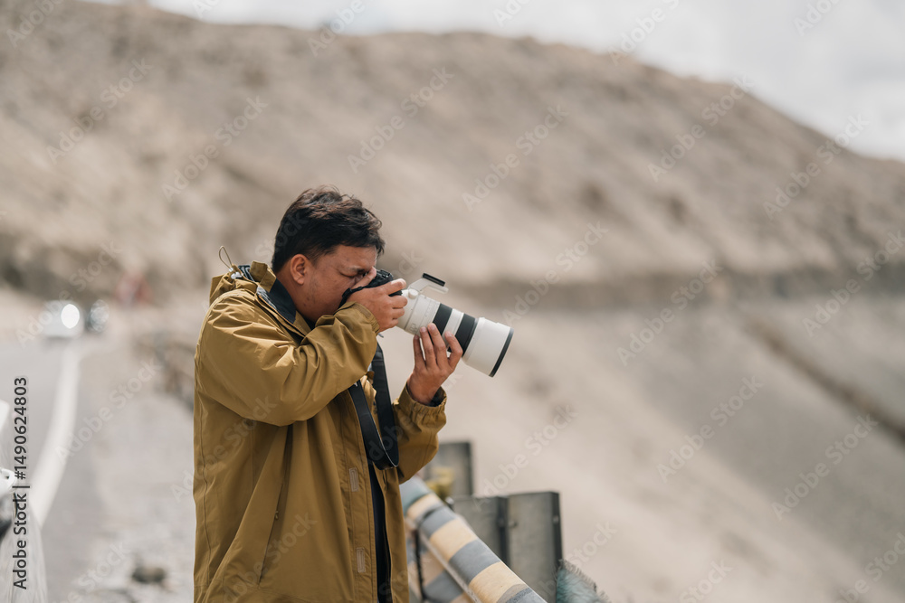 Fototapeta premium Photographer exploring Leh Ladakh with professional camera gear, capturing breathtaking mountain landscapes and documenting adventure travel in Northern India Himalayan region