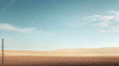 Fototapeta Naklejka Na Ścianę i Meble -  Vast desert landscape under a clear blue sky with a few wispy clouds.