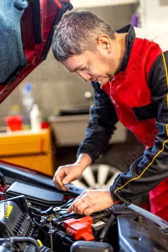Technician checking dipstick for level oil in engine car in garage. Engine service check, oil dipstick detail in service. Engine problems, engine repair at a car repair shop
