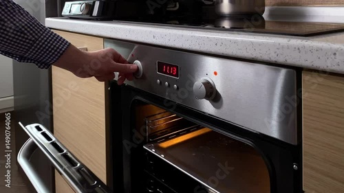 The man turns on the electrical oven in the kitchen to cook food. We cook at home.