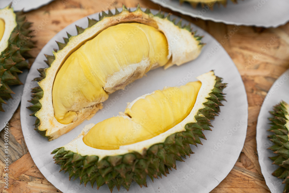 Fototapeta premium Ripe Durian Fruit Halves on Paper Tray – Tropical Thai Delicacy