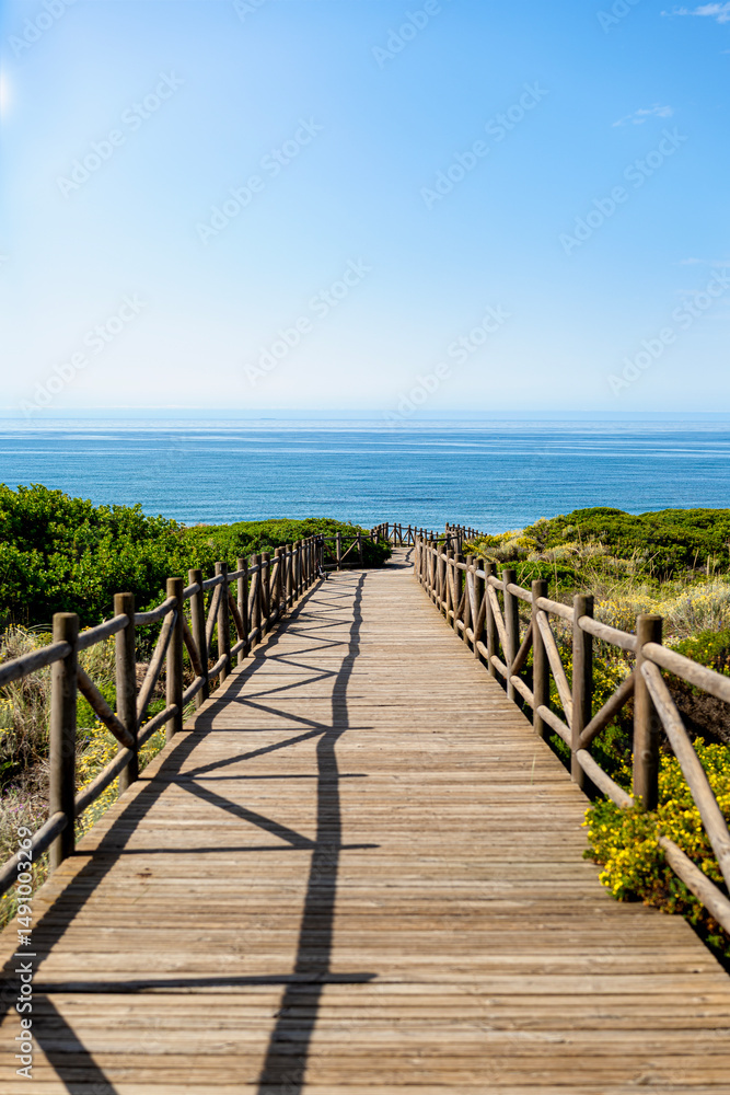Obraz premium Wooden footbridge between dunes towards the Mediterranean Sea