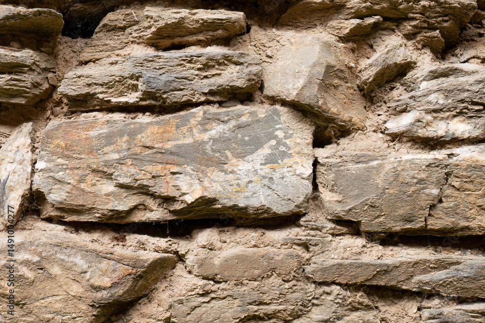 Fototapeta premium Closeup of ancient stone wall with large weathered rocks
