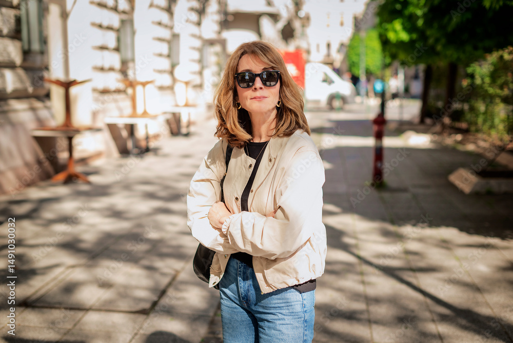 Fototapeta premium Blond haired woman standing at the city street