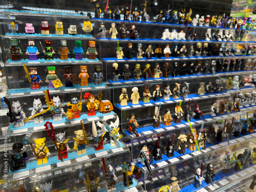 Fototapeta premium Moscow, Russia, April 25, 2025: Large variety of themed Lego minifigures on display inside Lego museum and retail corner, including characters from Minecraft, Star Wars and other popular franchises